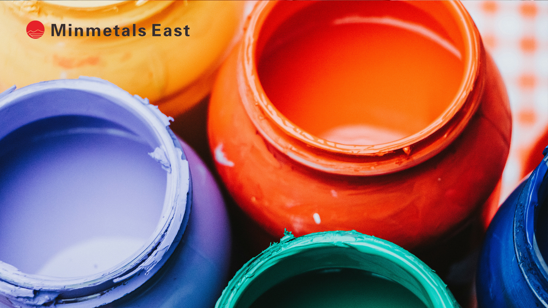 Open paint cans in various colors with the "Minmetals East" logo in the upper left corner.